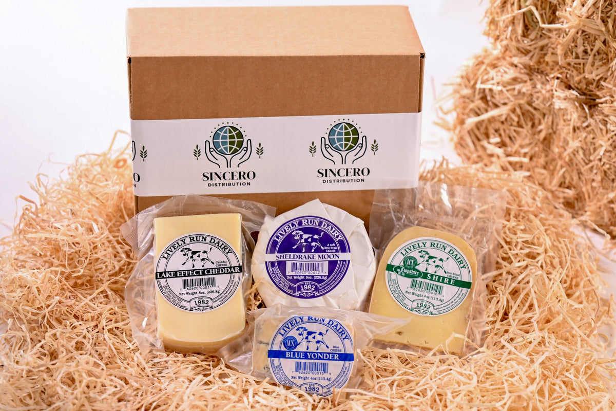 Packaged cheese items with 'Sincero' branding on a bed of straw.